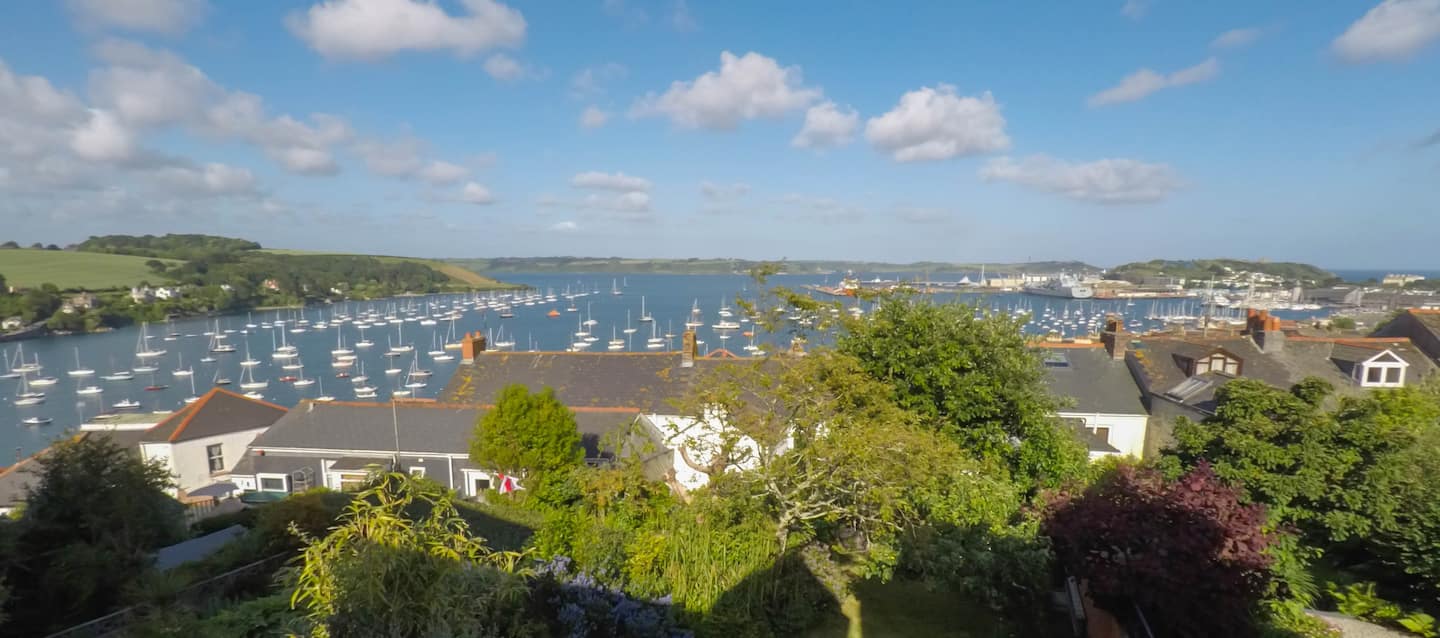 View over garden and rooftops to Falmouth harbour full of sailing boats