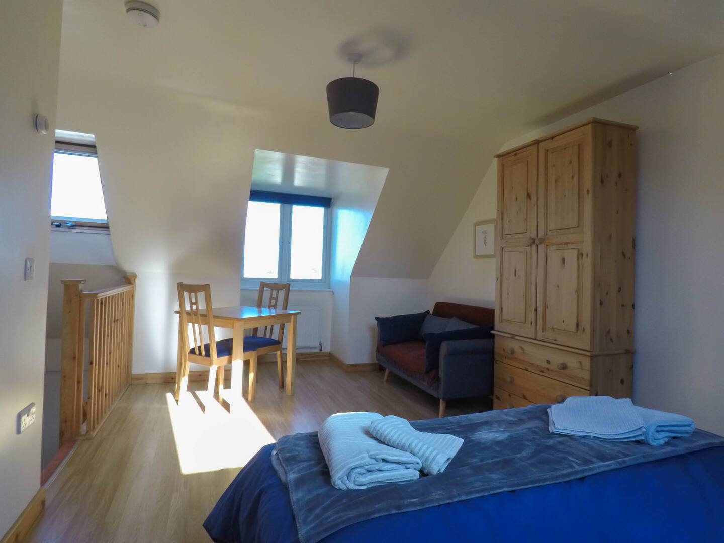Sunny living area with dining table, sofa and wardrobe